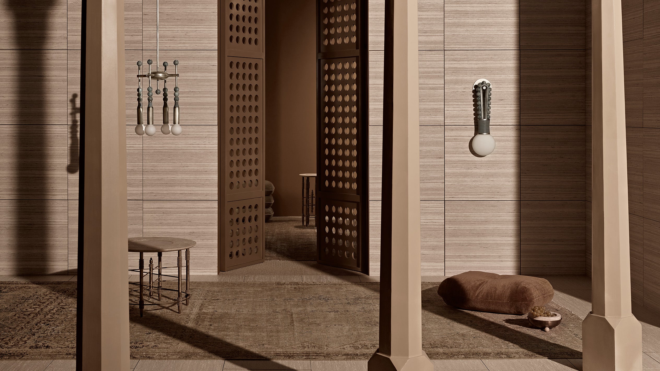 Minimalist interior with wooden columns, perforated wooden doors, a small bench, and a dog bed with a chew toy.