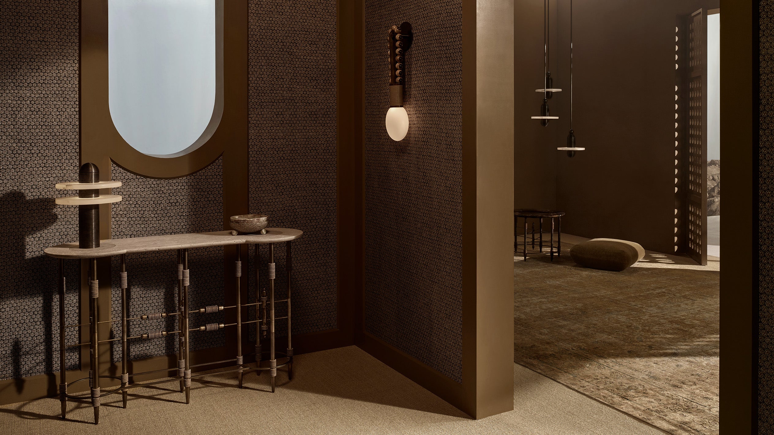 Minimalist interior with textured walls, a slim console table, round mirror, and soft natural light filtering through an open doorway