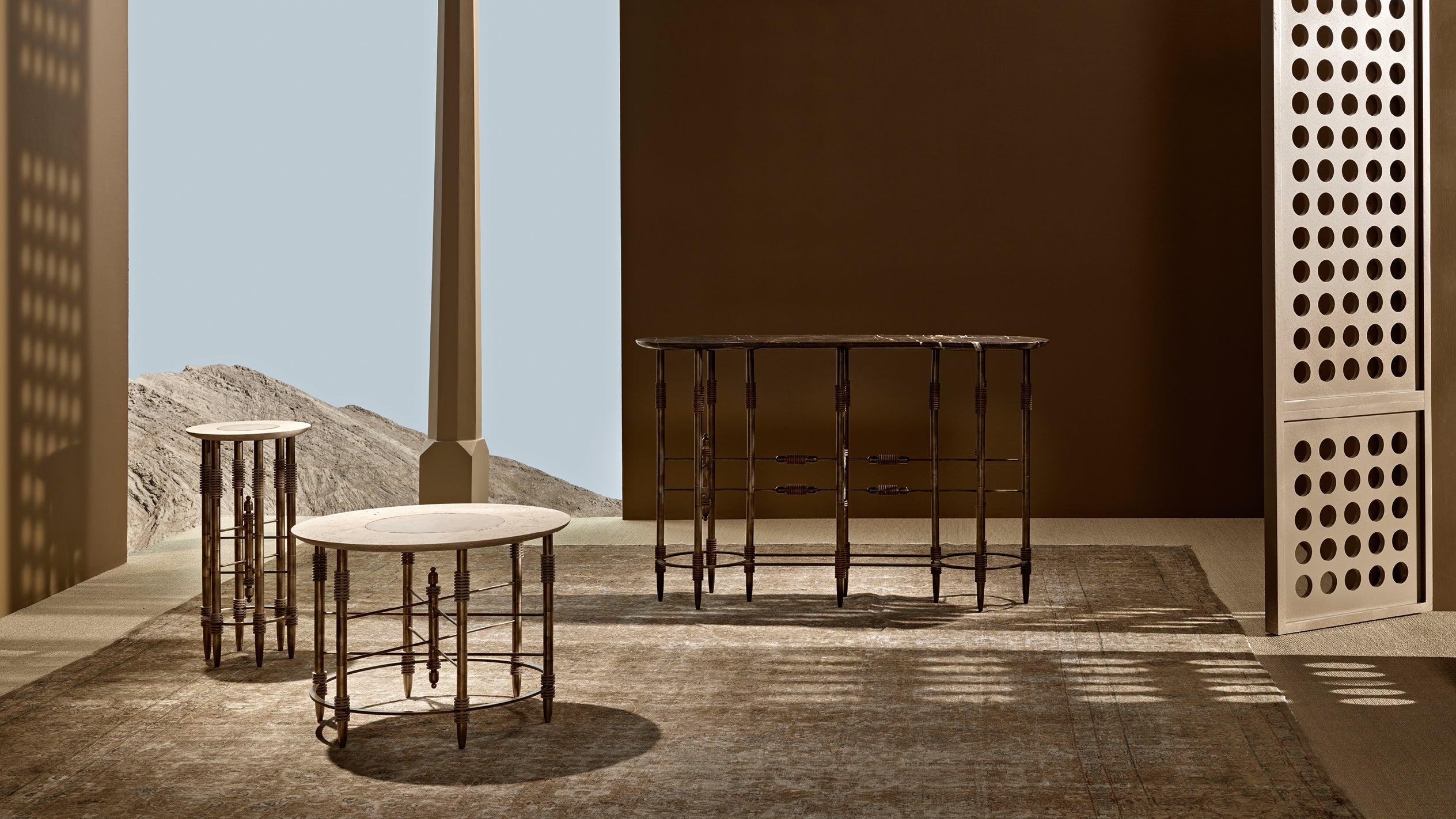 Three slender wooden tables with round tops casting shadows on a textured rug in a minimalist interior setting