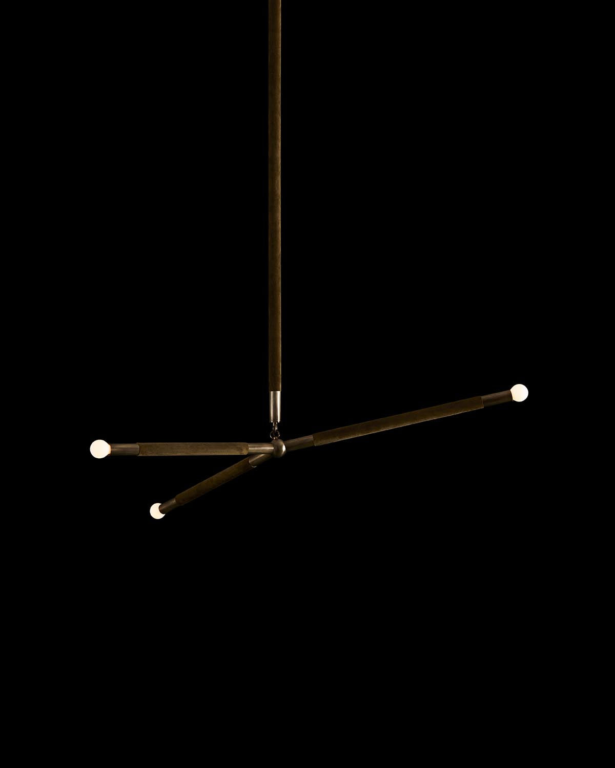 Minimalist three-arm ceiling light fixture with slim dark metal rods and round bulb ends against black background