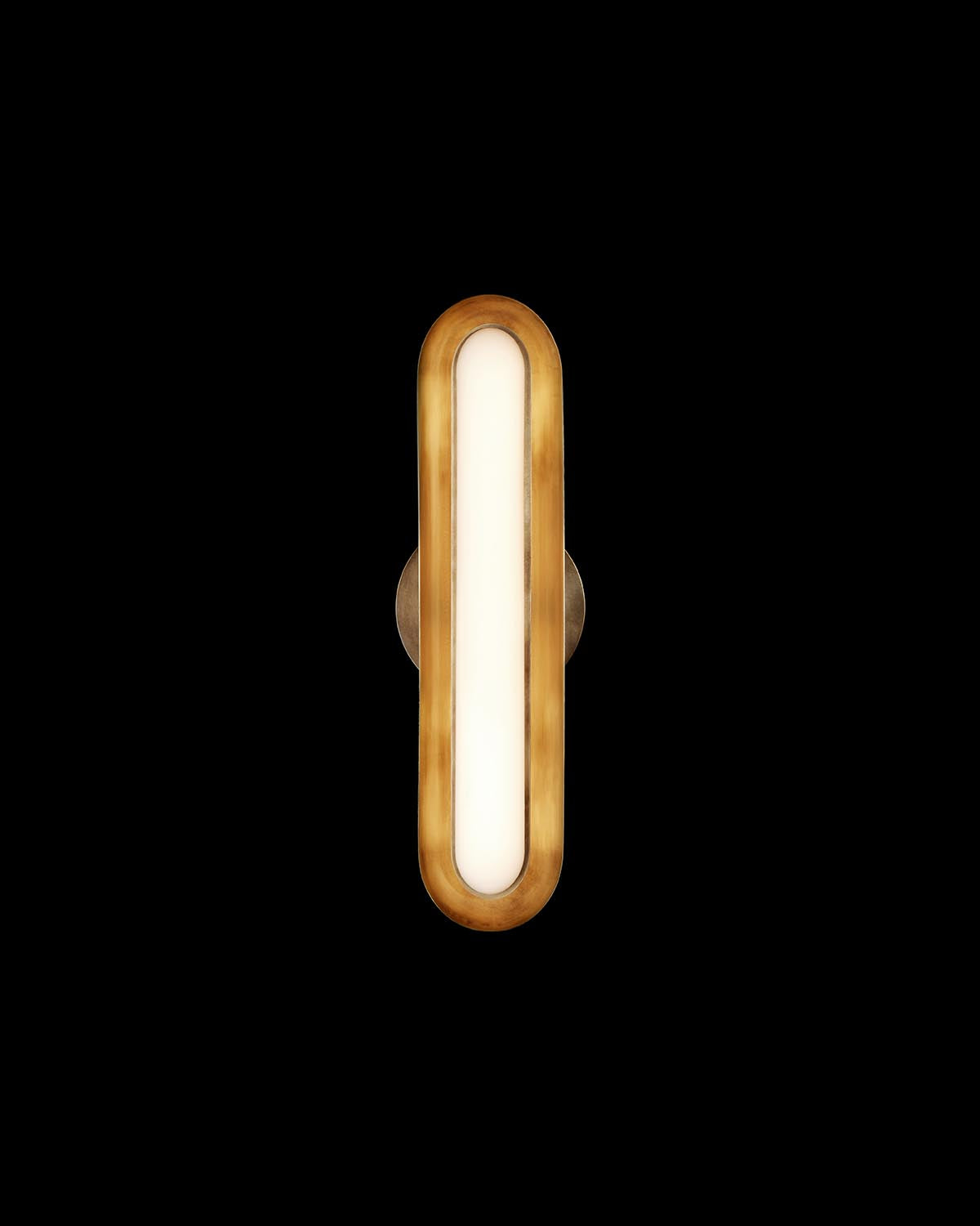 Vertical elongated wall light fixture with warm brass frame and soft white illumination against black background