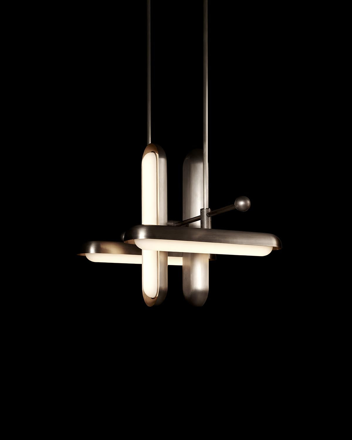 Modern pendant light fixture with four alternating horizontal and vertical frosted glass tubes and metal accents on black background