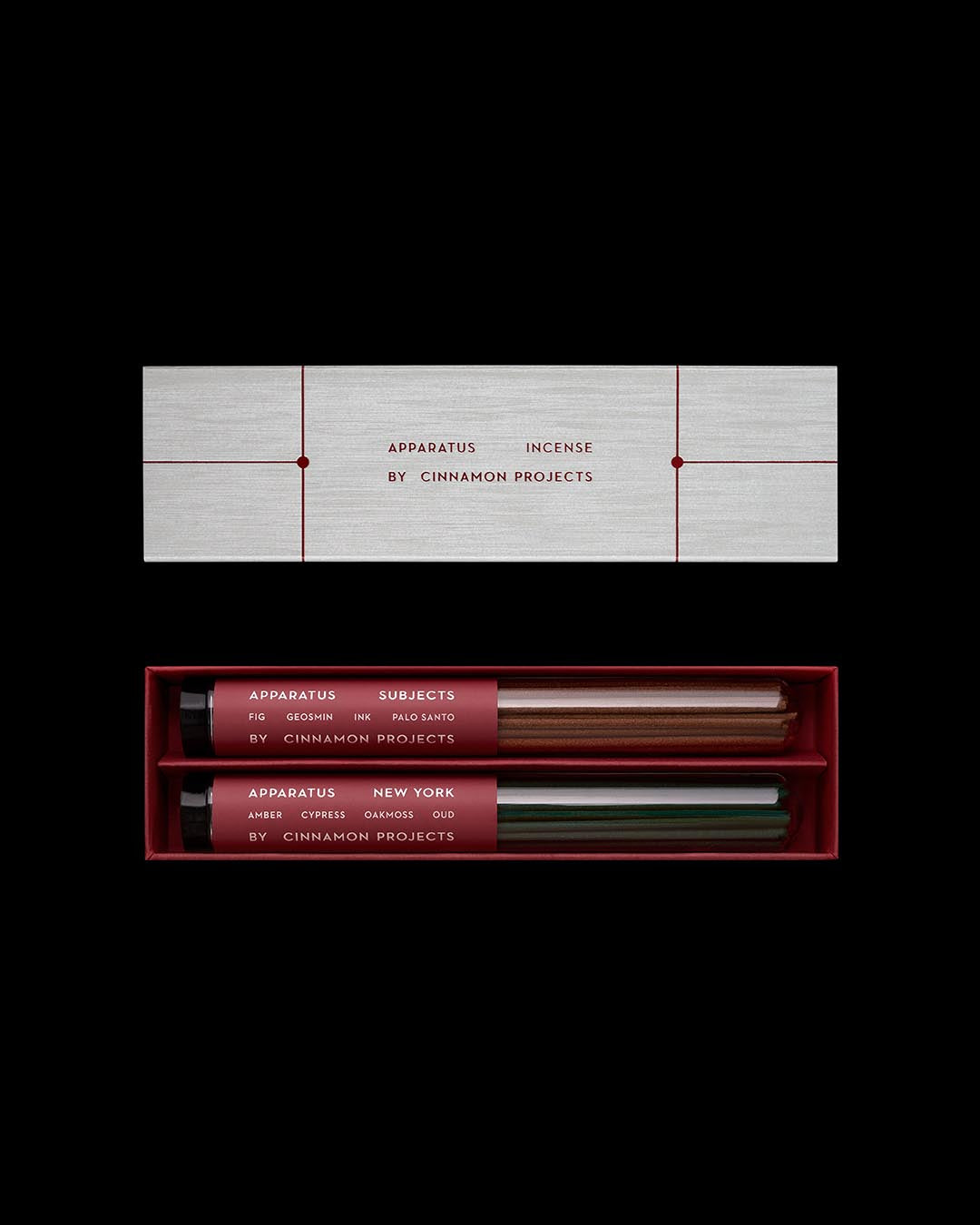 Minimalist rectangular box with two glass tubes of incense labeled in deep red and black on a black background