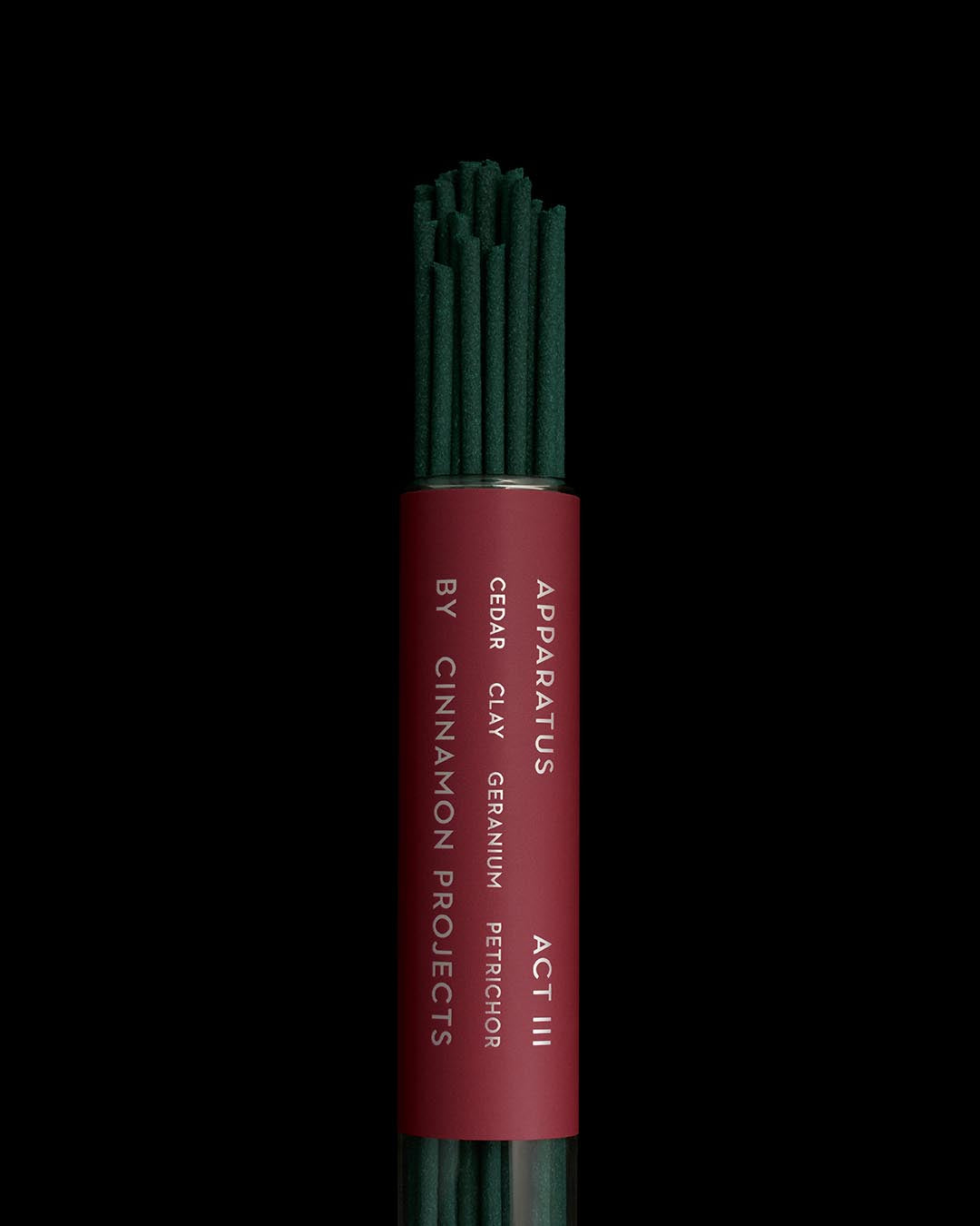 Bundle of dark green incense sticks with a deep red label featuring white text on a black background