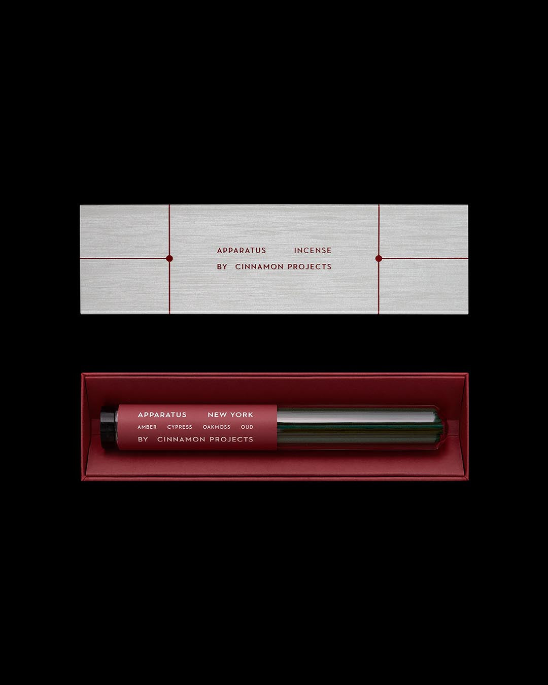 Minimalist rectangular incense packaging with red interior holding dark glass tubes labeled Apparatus New York by Cinnamon Projects