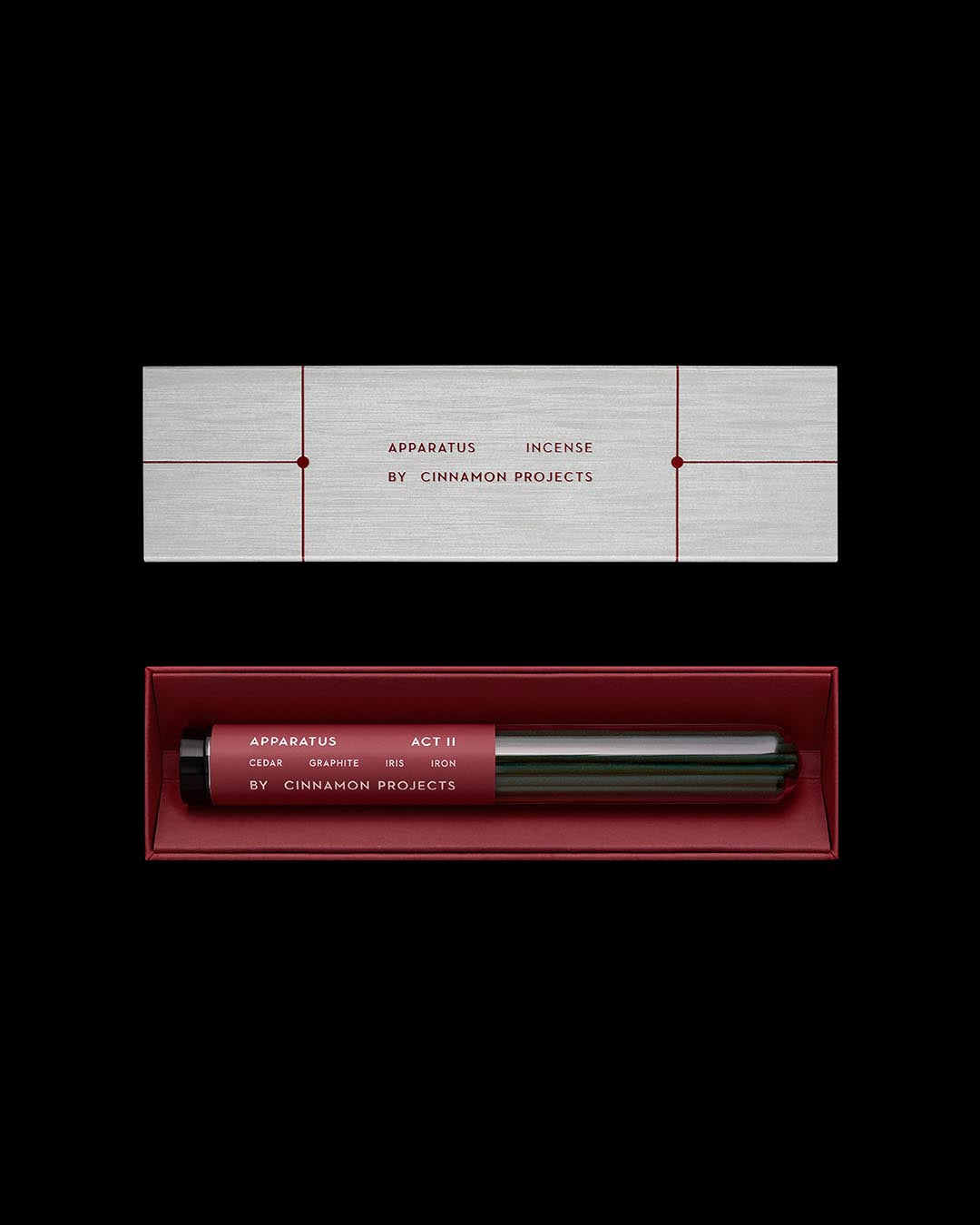 Rectangular silver box with minimalist red text and incense sticks in a red tray below, on a black background
