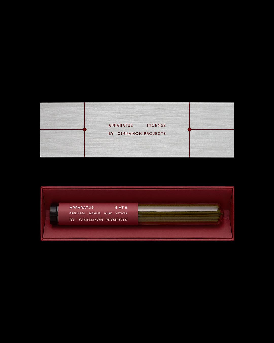 Rectangular box with minimalist text containing incense sticks in a glass tube on a dark background