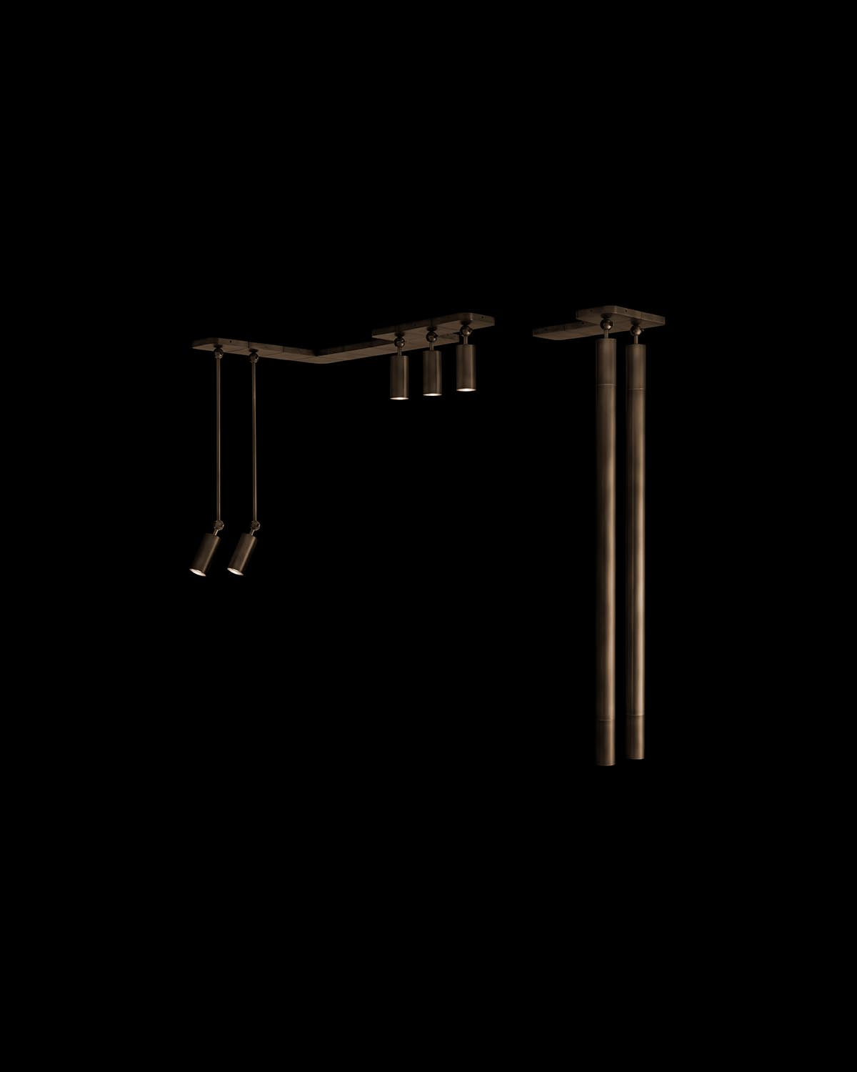 Close-up of bronze-toned cylindrical pendant light fixtures with adjustable spotlights on a black background