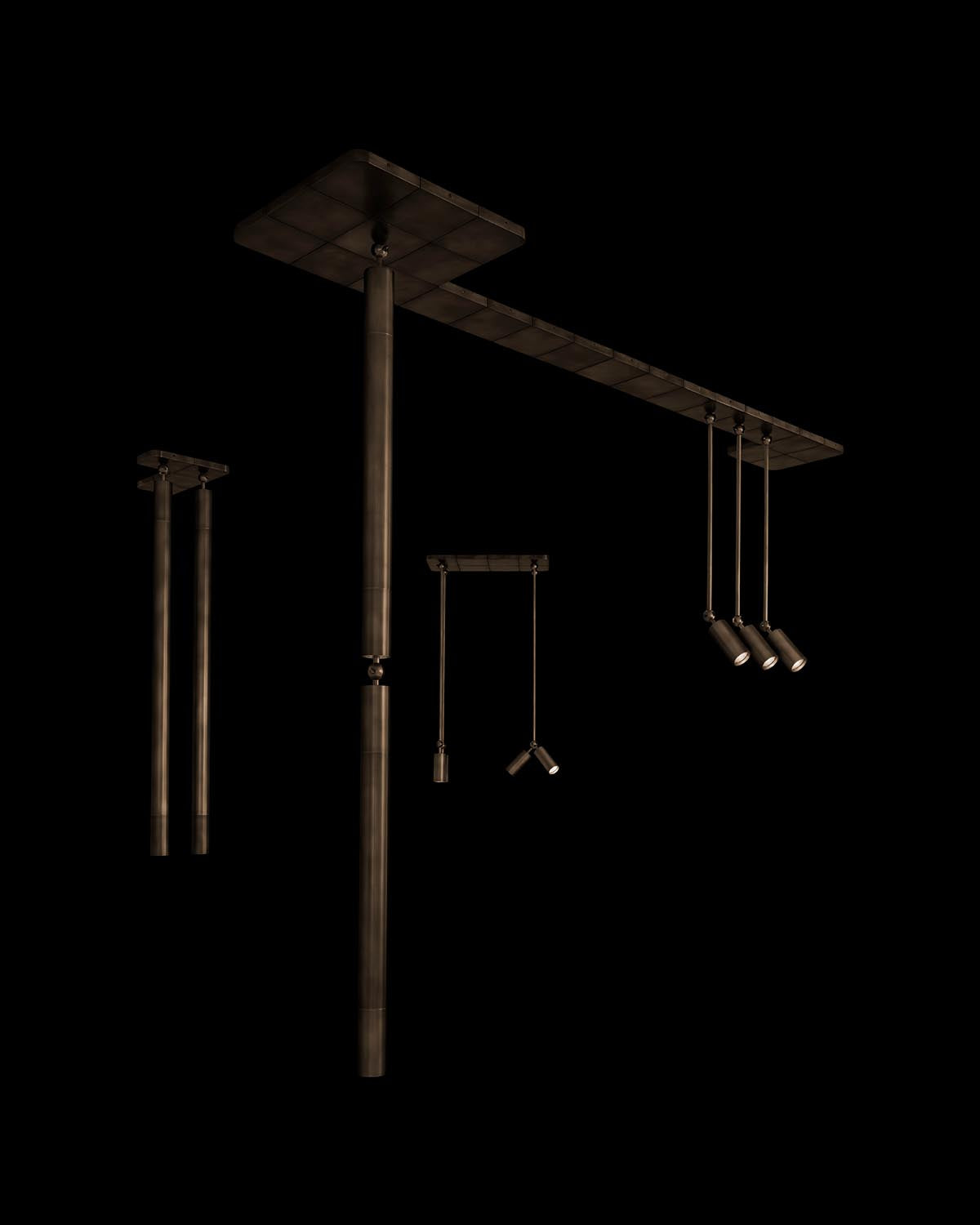 Set of dark metal cylindrical pendant lights with adjustable hanging rods against a black background