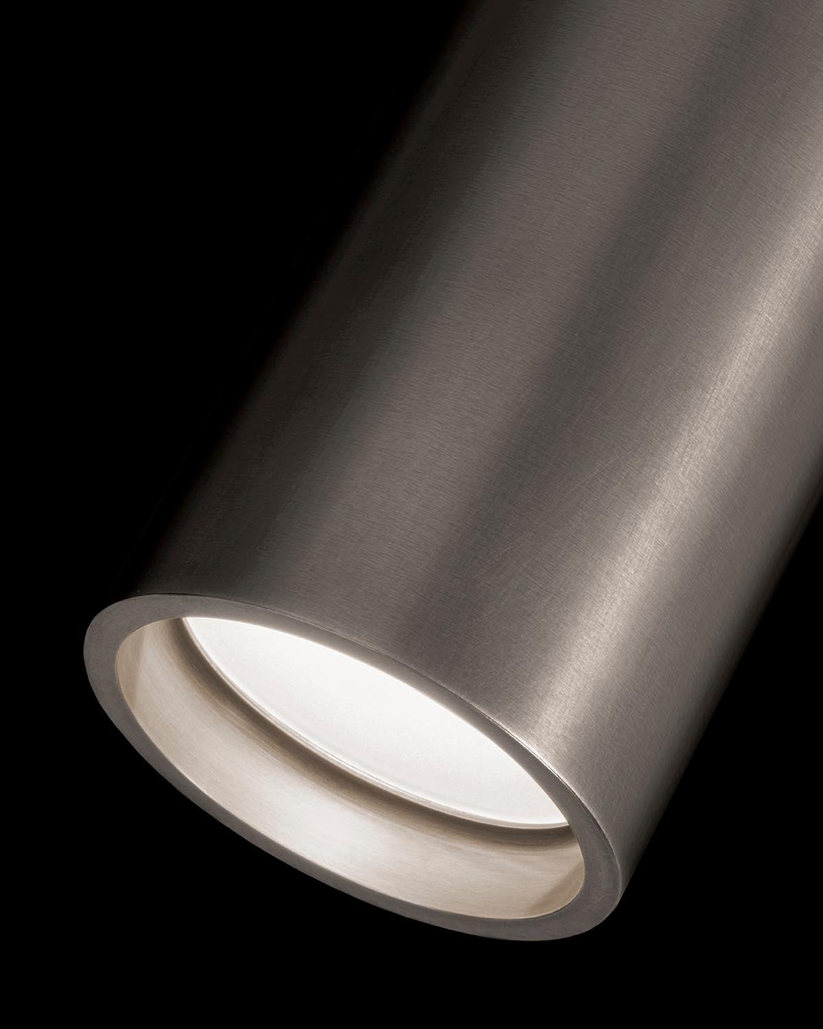 Close-up of a brushed metallic cylindrical light fixture with a recessed LED bulb and smooth matte finish