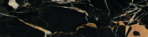 Close-up of black marble surface with beige and white irregular veins and natural textured patterns