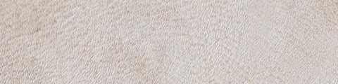 Close-up of a textured beige fabric surface with subtle irregular patterns and soft natural fibers.
