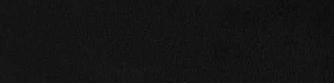 Close-up of black suede texture with soft, velvety surface and fine, slightly uneven nap across the material