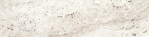 Close-up of a light beige travertine stone surface with natural pitting and textured patterns on a horizontal plane