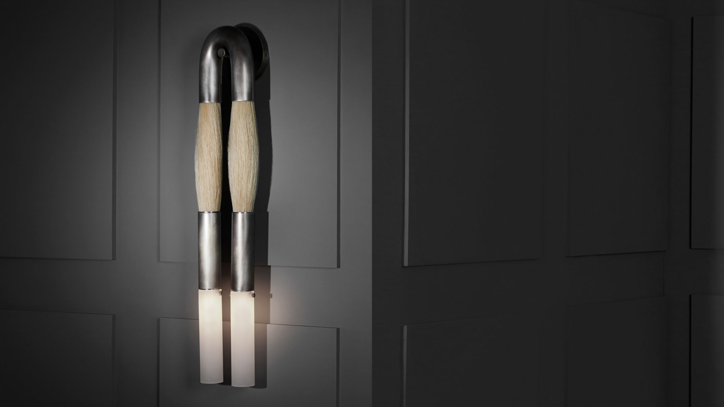 Pair of modern wall sconces with tapered beige shades and wooden accents on a dark paneled wall background
