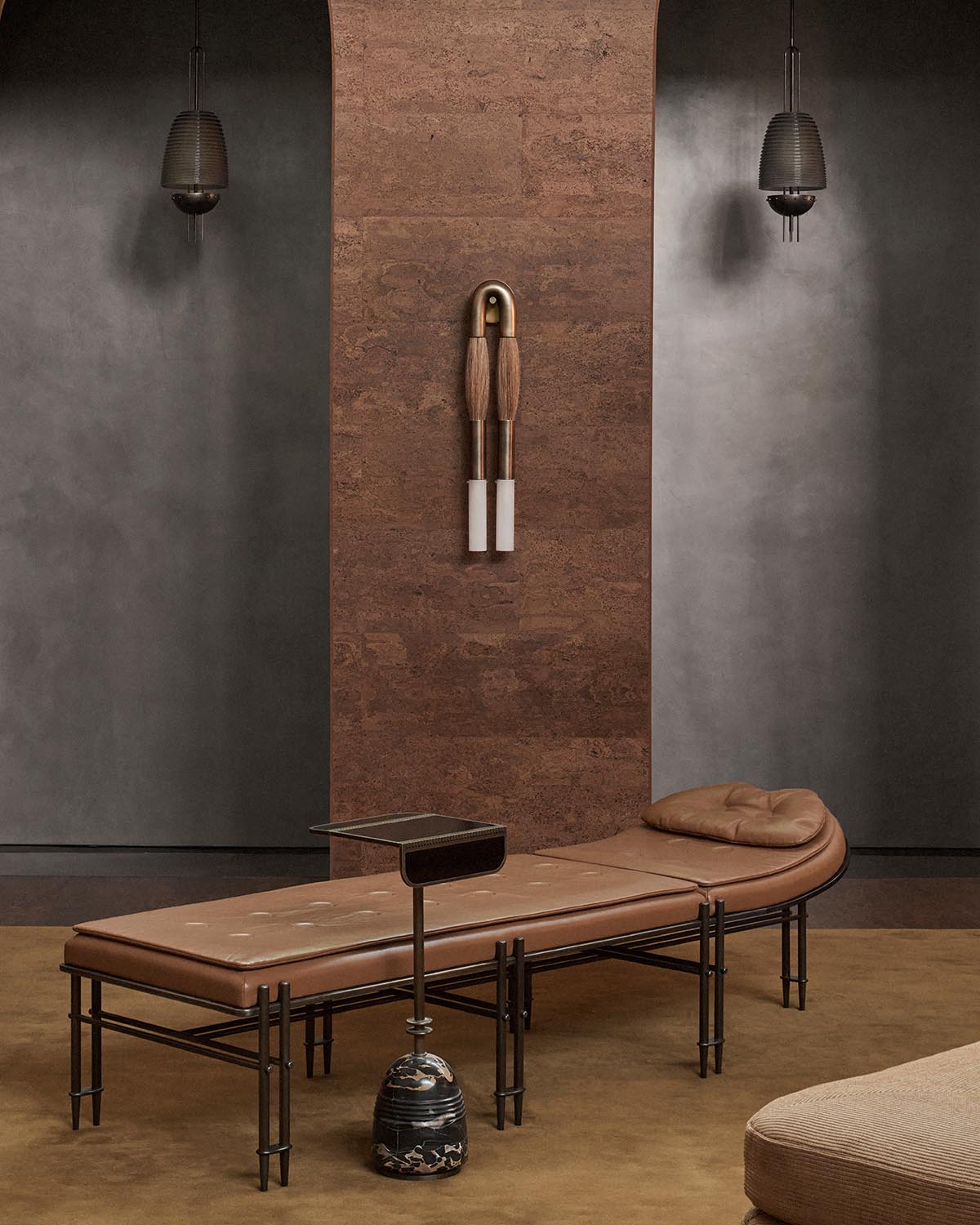 Pair of modern horsehair sconces with brass and white cylindrical details mounted on textured brown wall panel