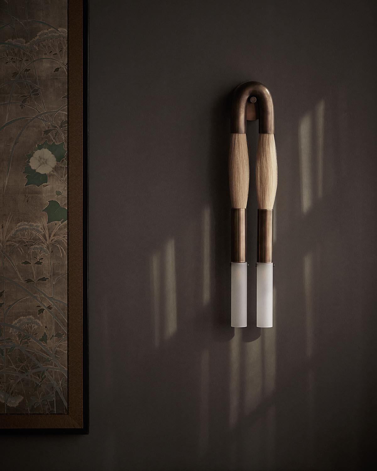 Pair of modern wall sconces with curved wooden arms and frosted glass shades mounted on a dark textured wall