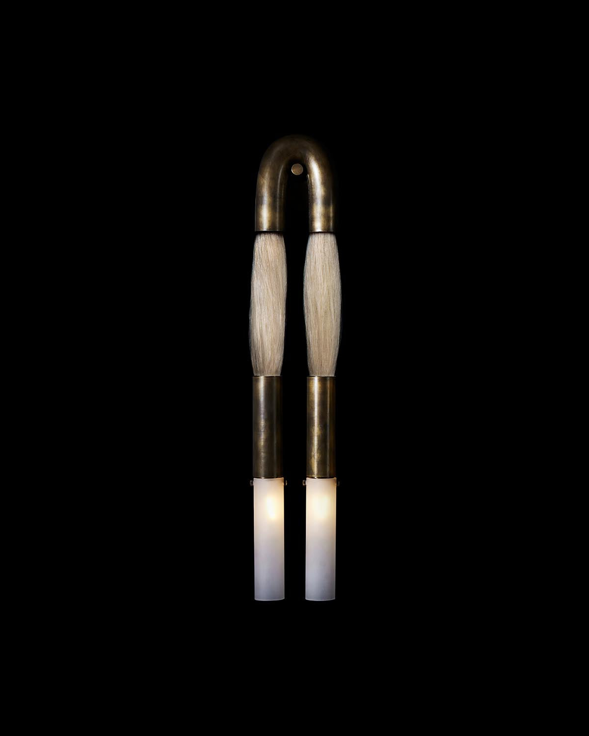 Wall-mounted light fixture with two brushed brass arms wrapped in light horsehair and frosted glass cylinders