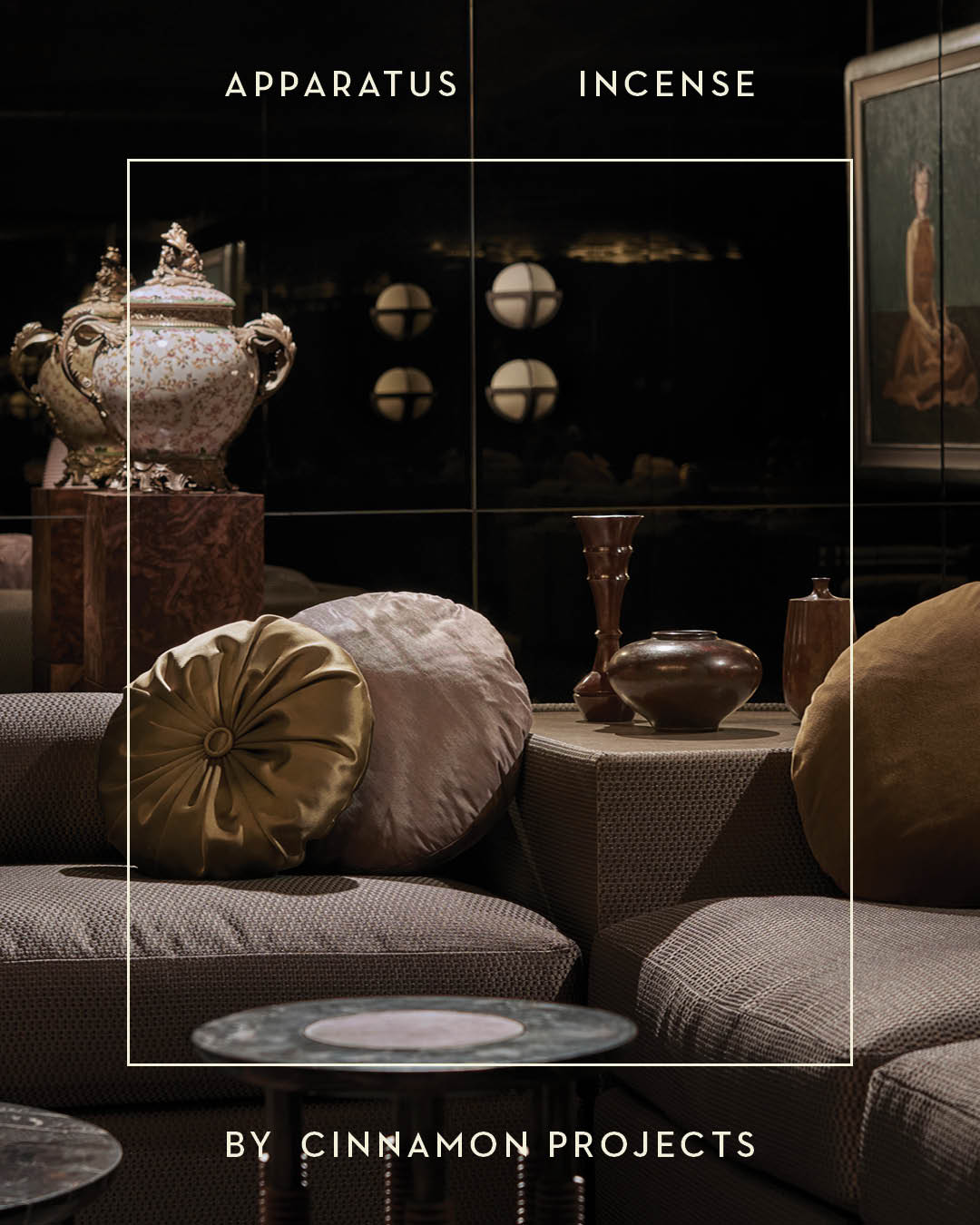 Warm-toned living room with textured sofas, round cushions, sculptural vases, and large ornate urns on dark shelves