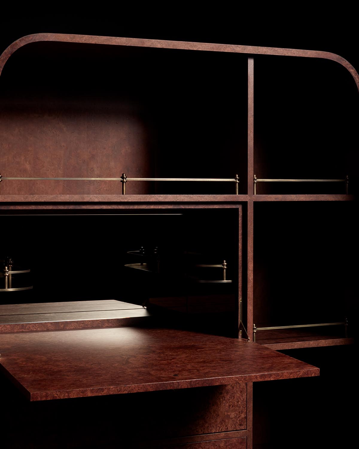 Close-up of dark wood cabinet variation with brass railings and fold-out surface against black background