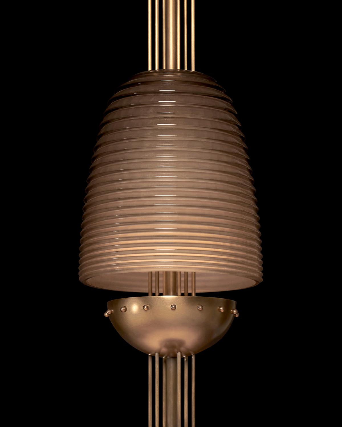 Close-up of a modern pendant light with ribbed frosted glass shade and metal details against a black background