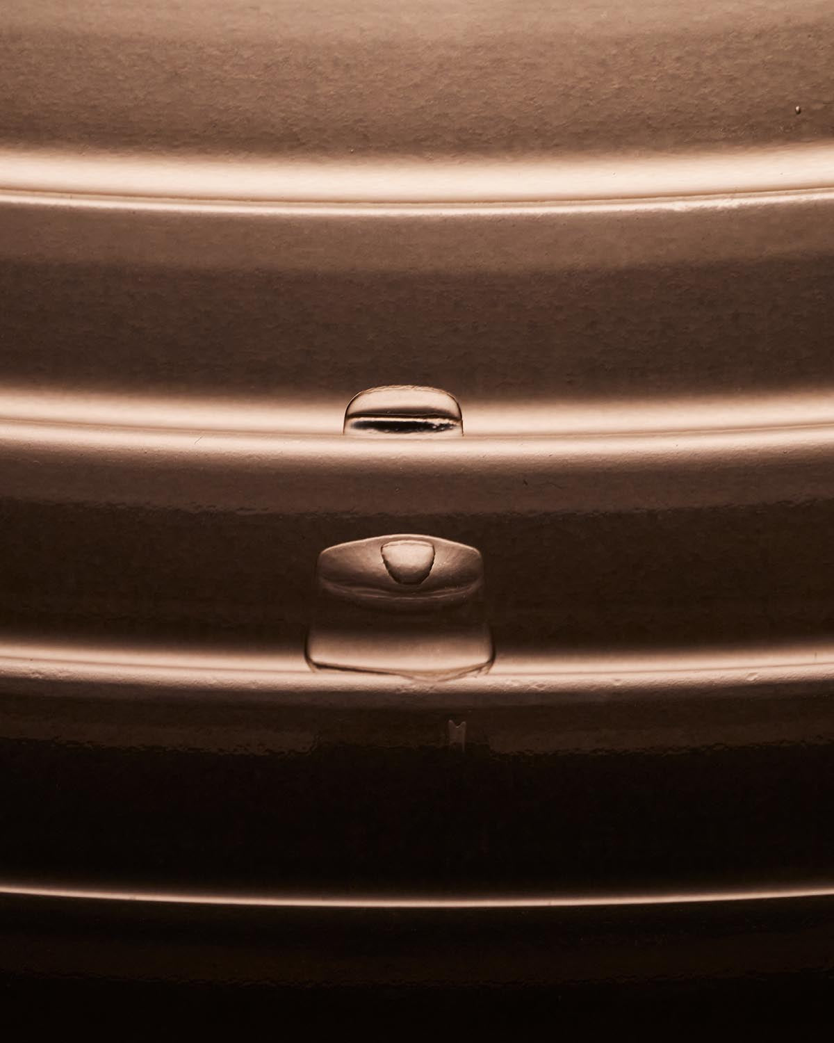 Close-up of smooth curved surface with highlighted rounded indents and soft lighting emphasizing texture and depth