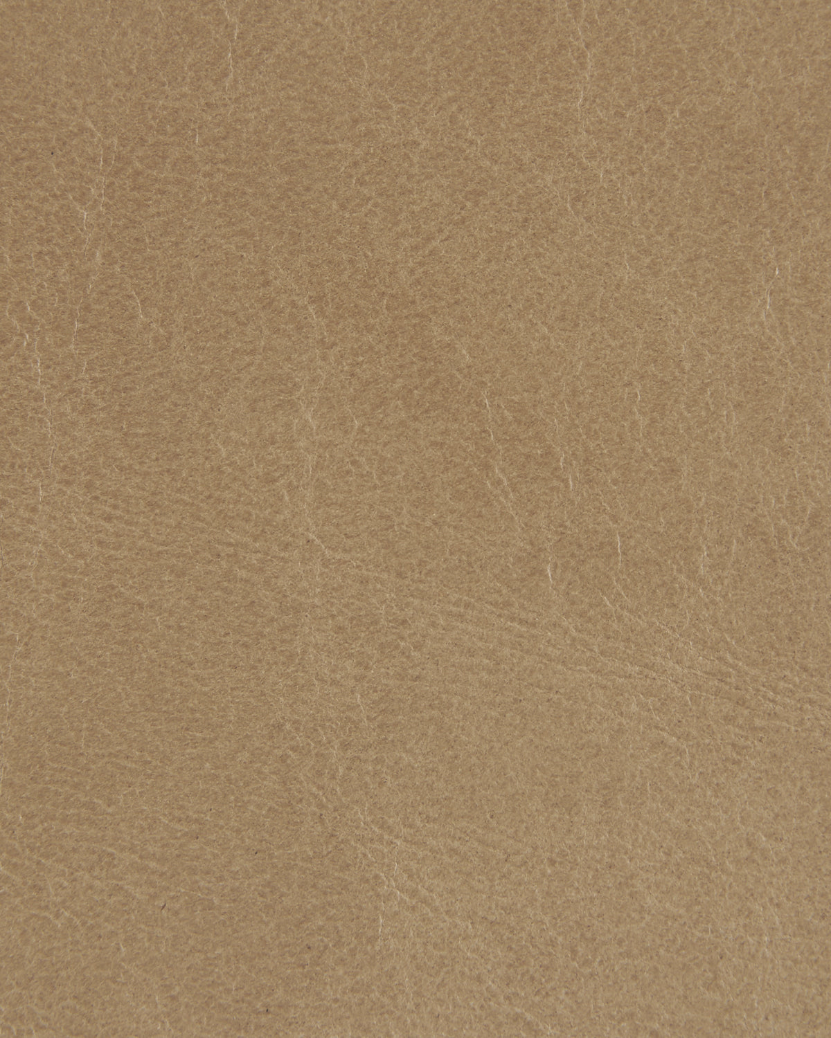 Close-up of light brown textured leather surface with natural creases and fine grain details visible