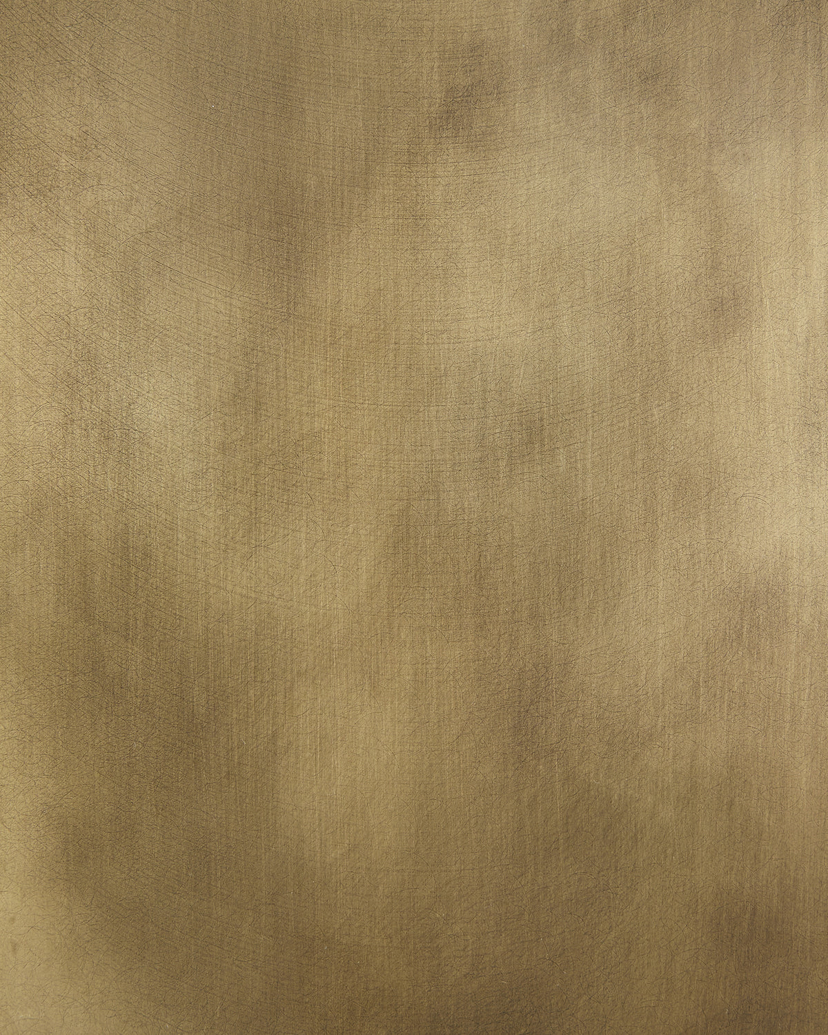 Close-up of a smooth, brushed brass metal surface with subtle texture and warm golden tones
