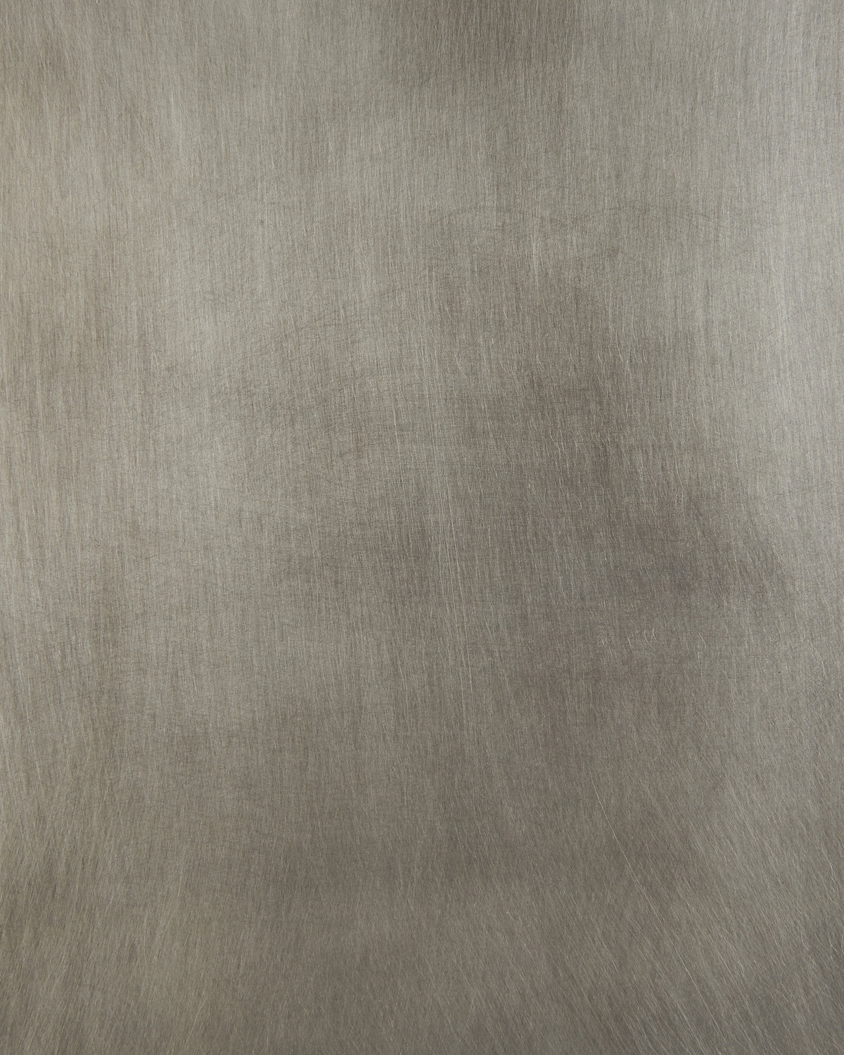 Close-up of a brushed metal surface with fine linear texture and muted silver-gray tones evenly distributed across the frame