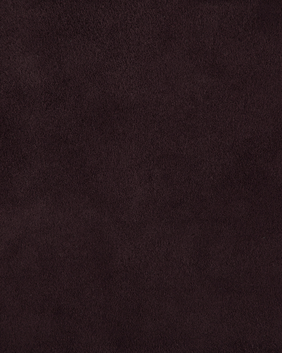 Close-up of dark brown suede texture with soft, slightly uneven surface and subtle natural grain pattern
