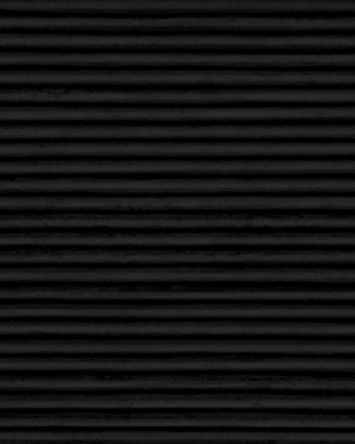 Close-up of horizontal black ridged surface with evenly spaced textured grooves creating a subtle pattern