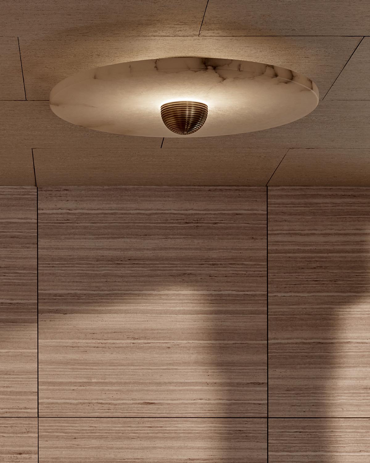Round marble ceiling light fixture with a dark central detail mounted on a beige textured ceiling panel