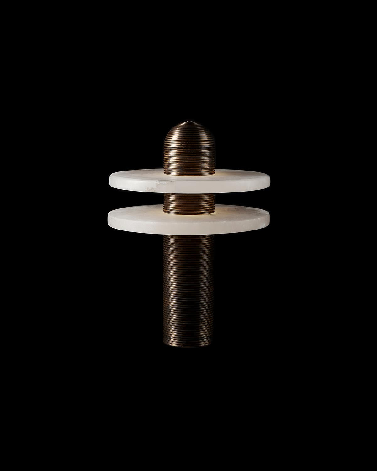 Modern table lamp with cylindrical ribbed bronze base and two flat white disc shades on black background