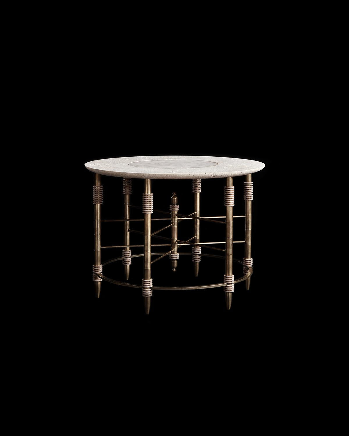 Round side table with a light stone top supported by intricate bronze metal legs wrapped in coiled detailing on black background