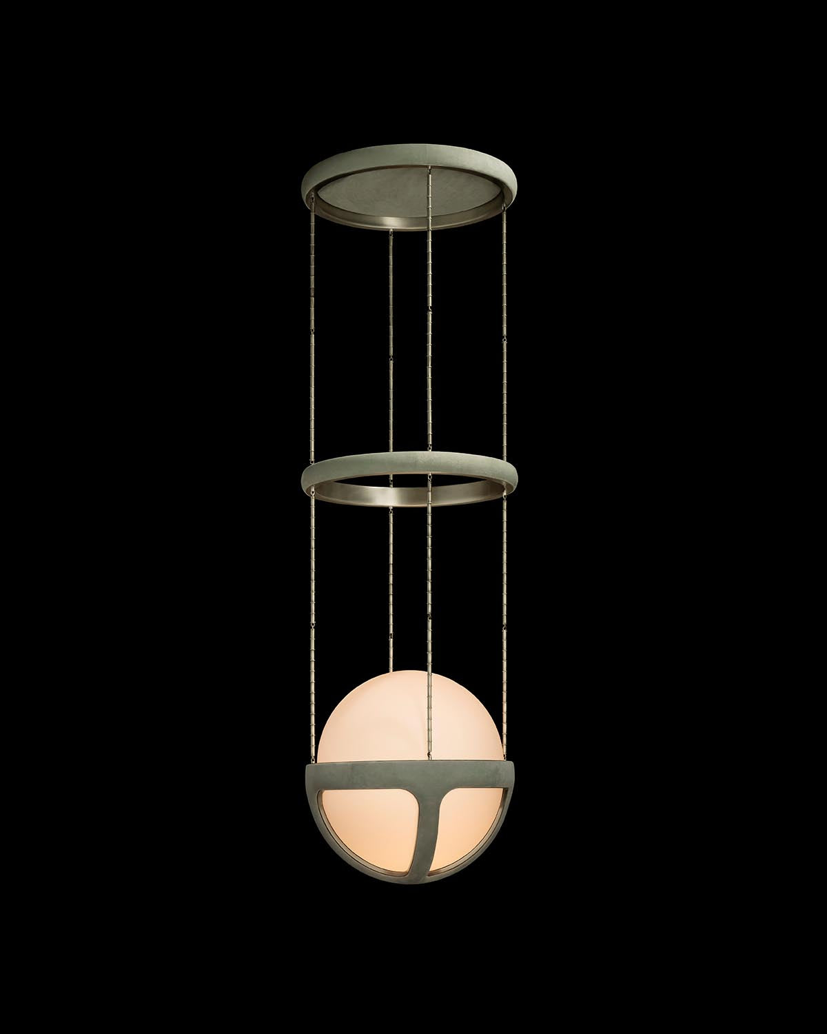 Modern pendant light with circular metal frame and glowing spherical glass diffuser suspended by thin rods on black background