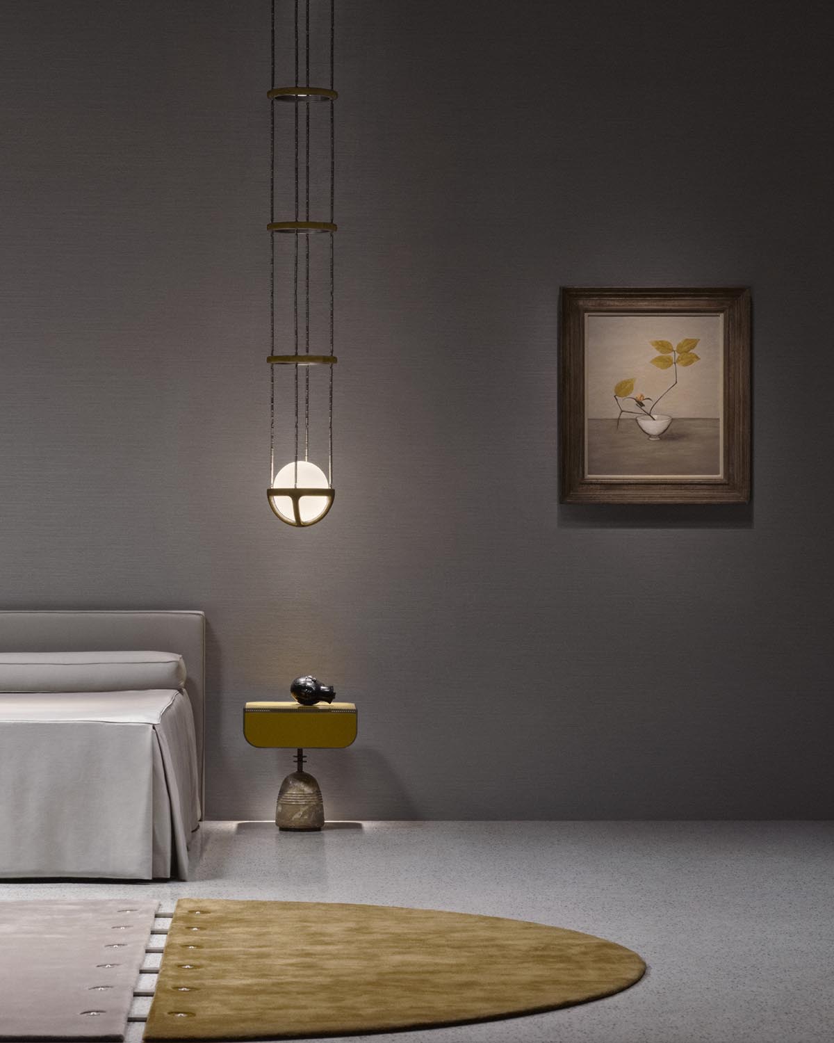 Minimalist bedroom corner with beige bed, yellow side table, round pendant light hanging by thin ropes, and framed botanical artwork