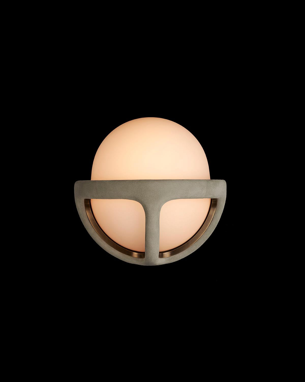 Close-up of spherical frosted glass sconce with geometric metal frame against a black background