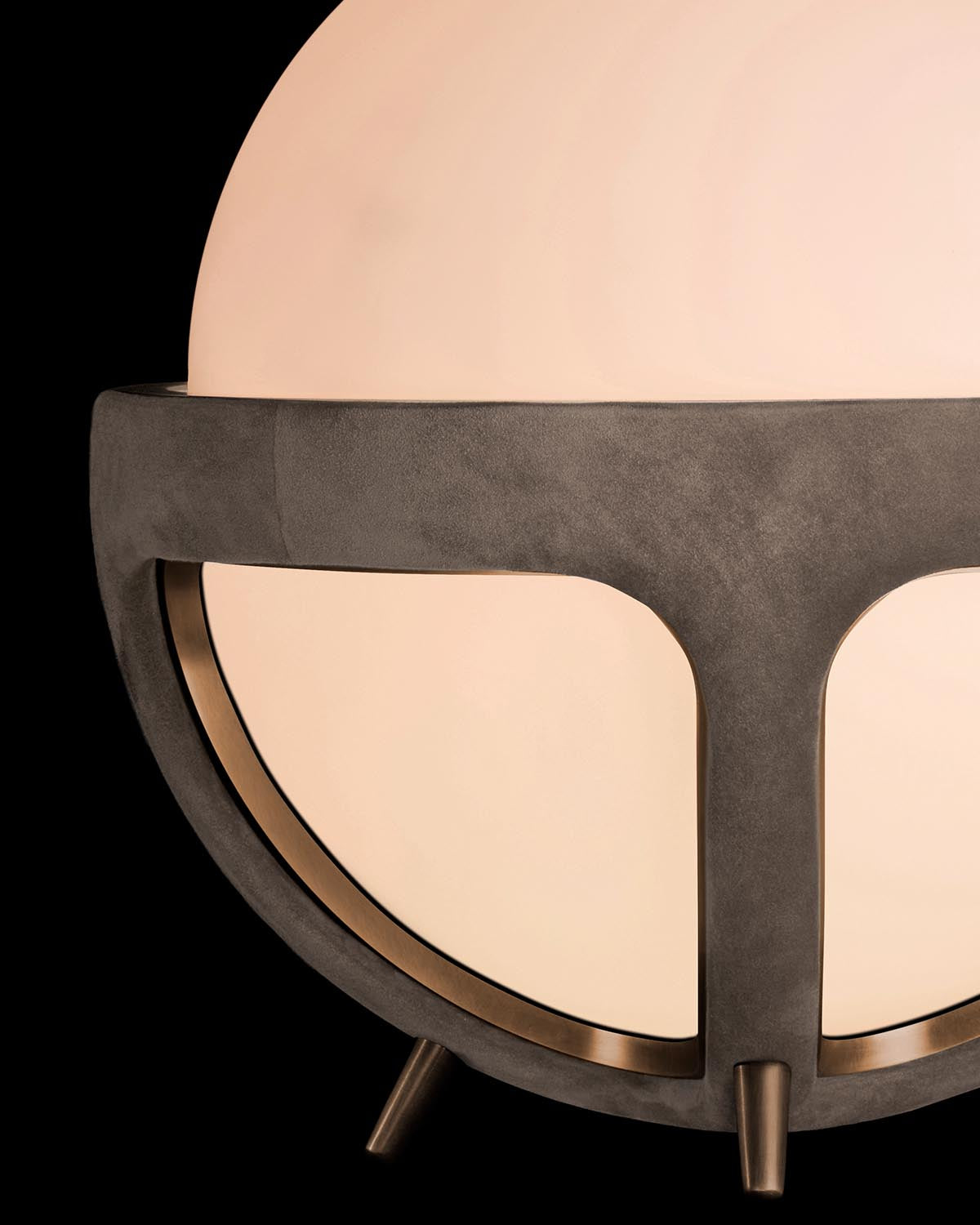Close-up of a medium round table lamp with a frosted glass globe and dark textured metal frame on a black background