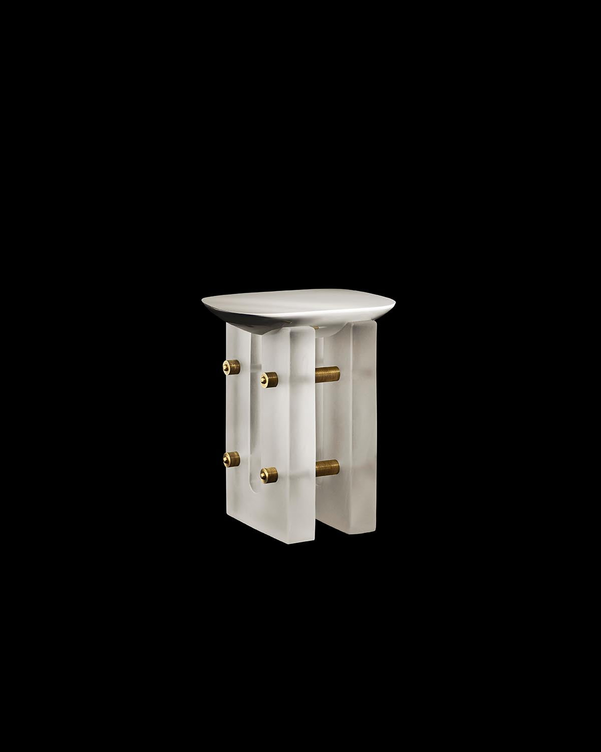 Sculptural ivory side table with flat top, thick rectangular legs, and exposed brass rod connectors on black background