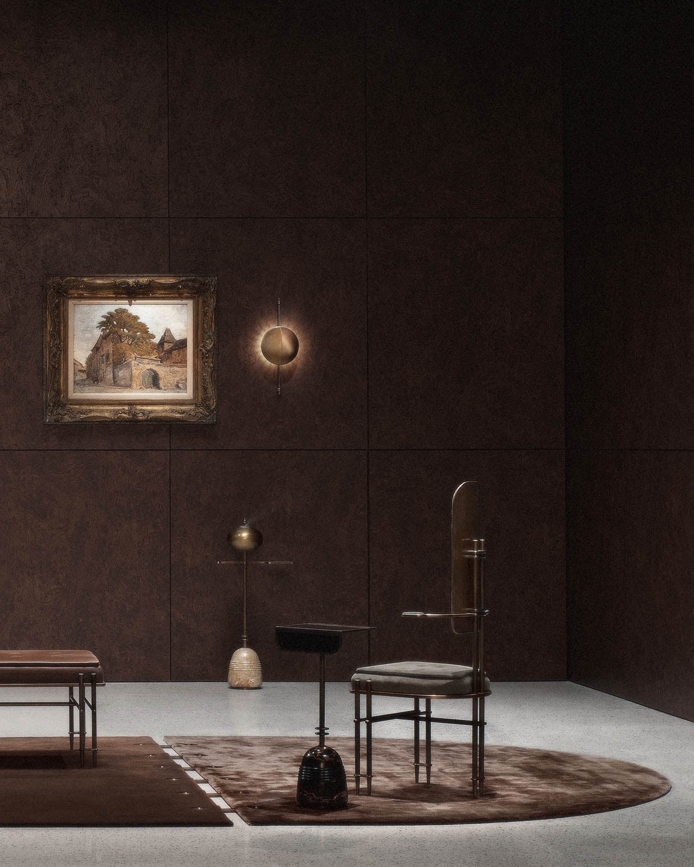 Minimalist interior with dark paneled walls, abstract brass and stone sculptures, a chair, and framed painting on wall