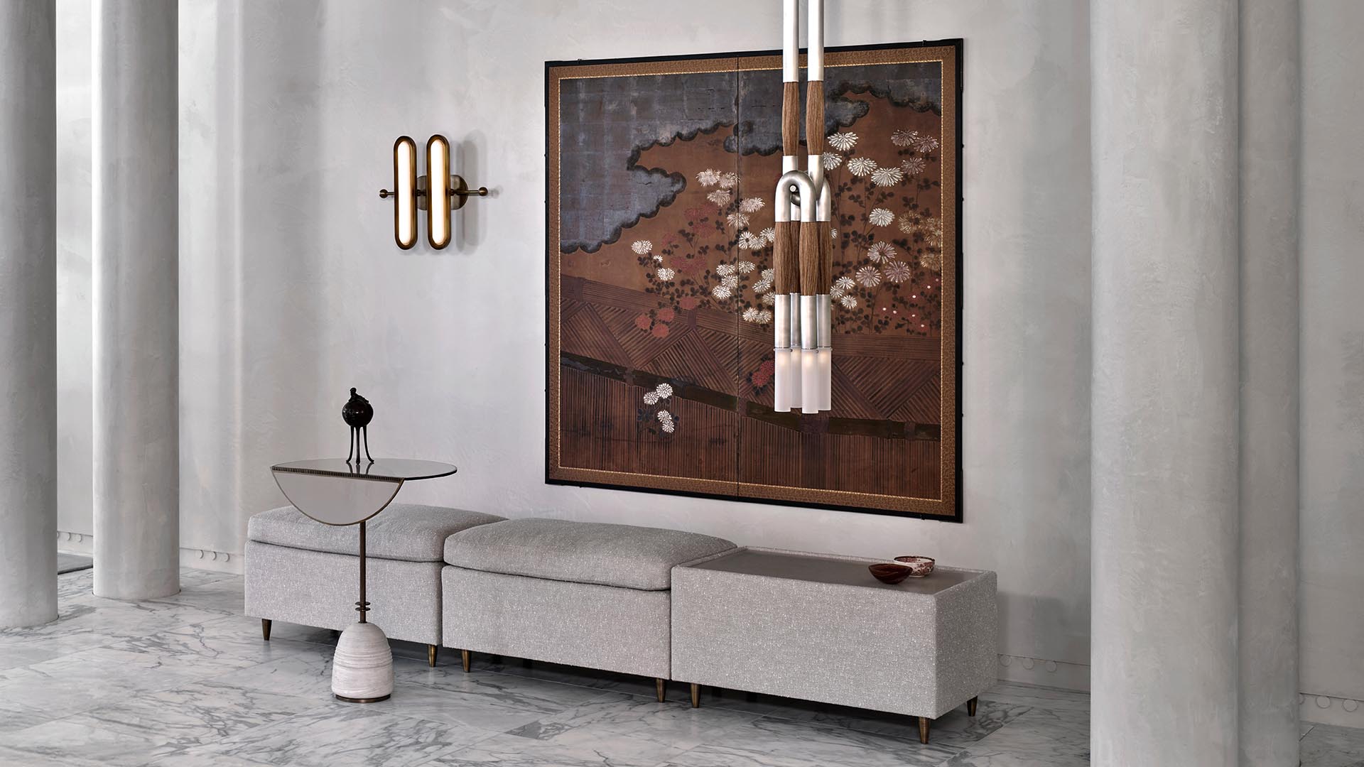 Minimalist interior with light gray bench, round marble side table, modern pendant light, and large framed artwork on textured wall