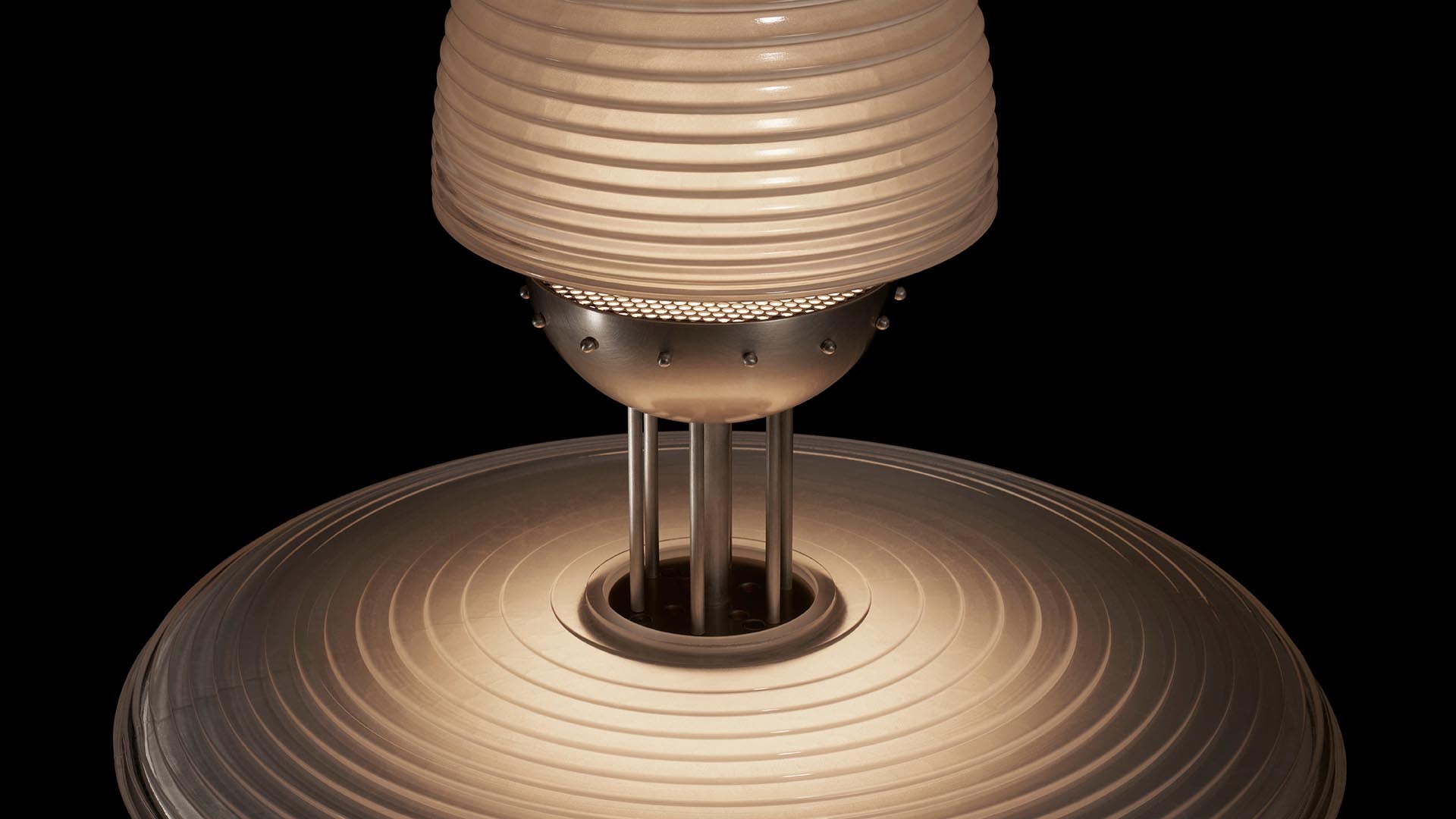 Close-up of a modern pendant light fixture with concentric circular patterns and metallic support rods against black background