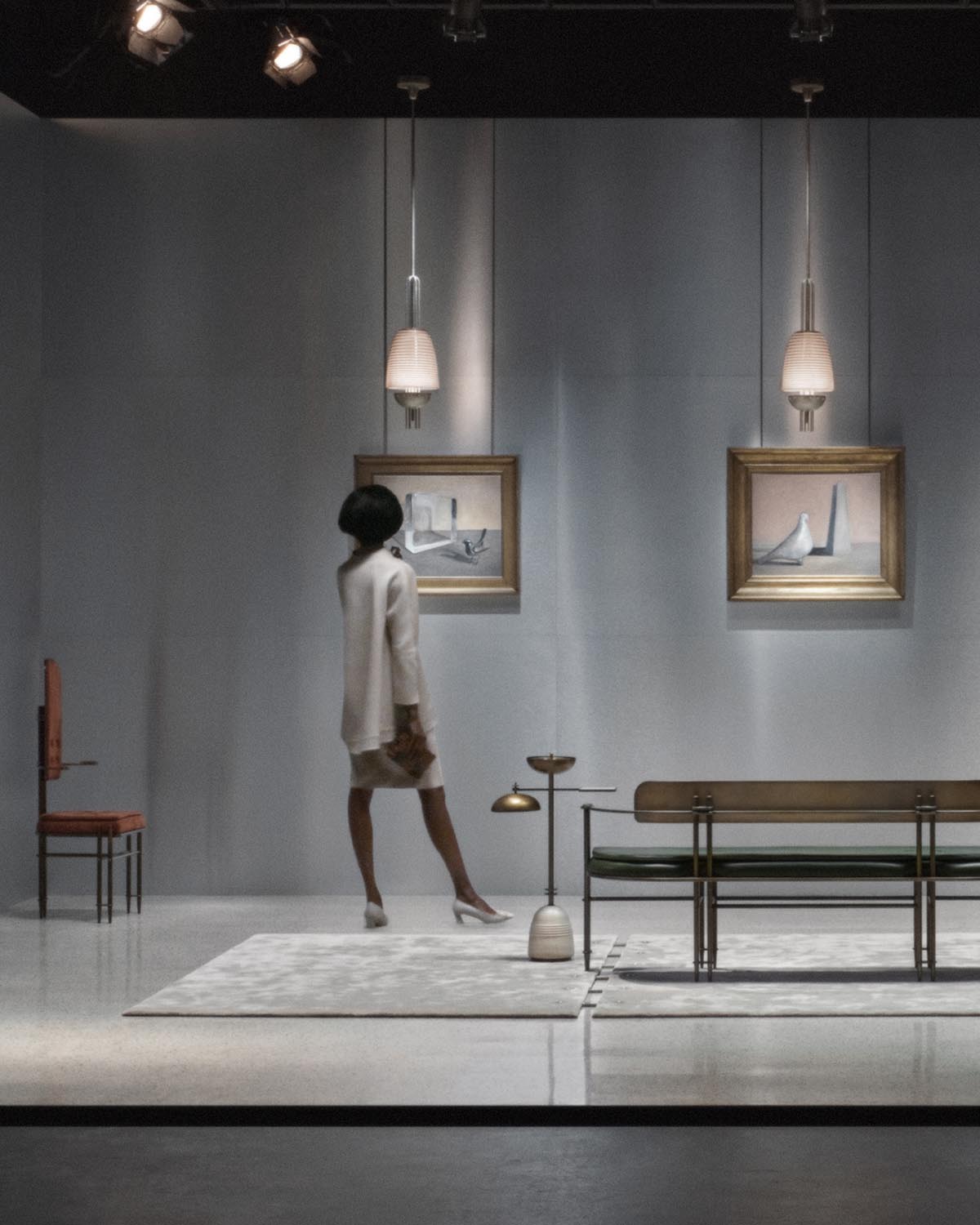 Modern pendant light with frosted glass shade hanging over minimalist gallery space with artwork and sculptural furniture