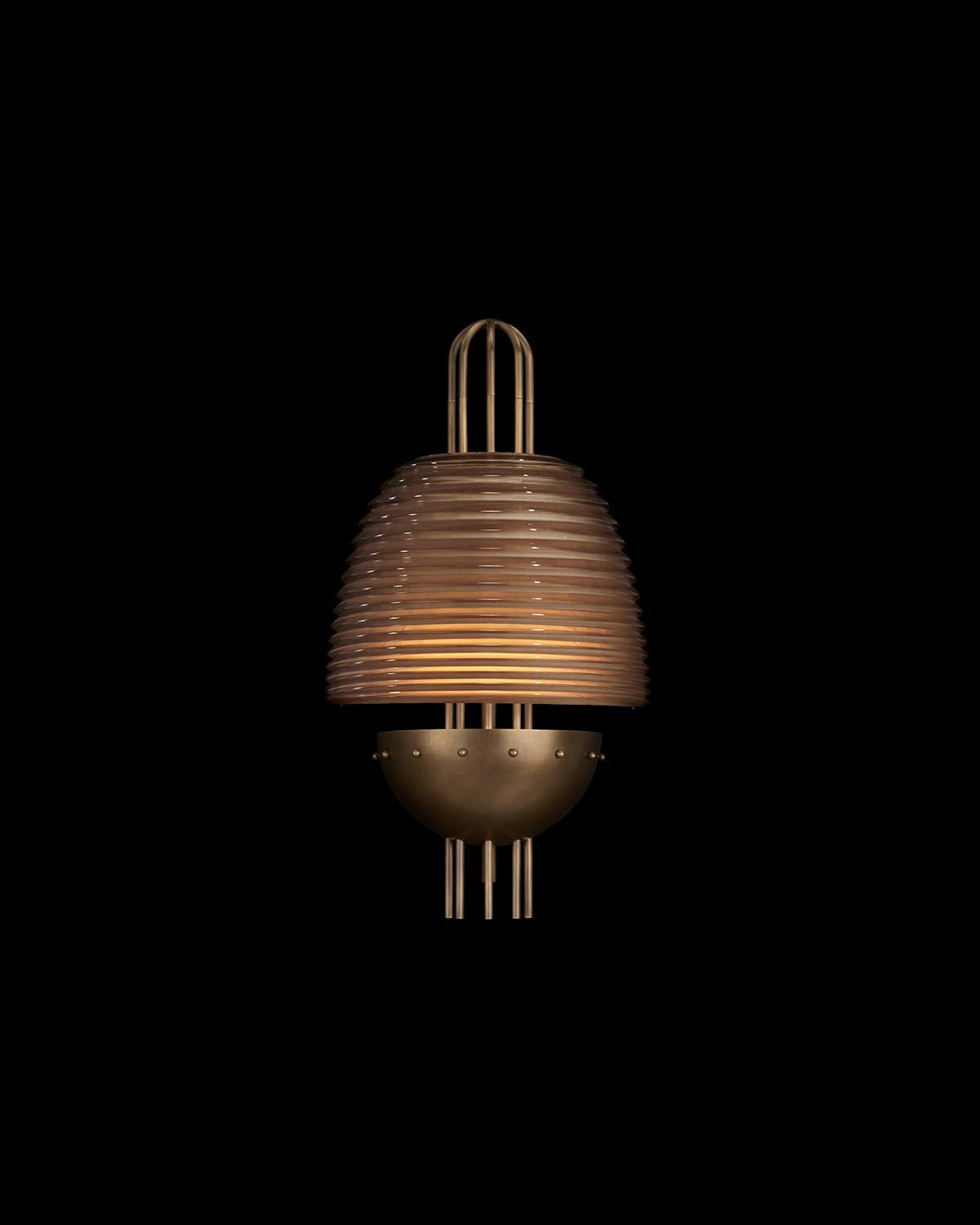 Wall-mounted light fixture with layered ribbed amber glass shade and aged brass half-sphere base with vertical rods