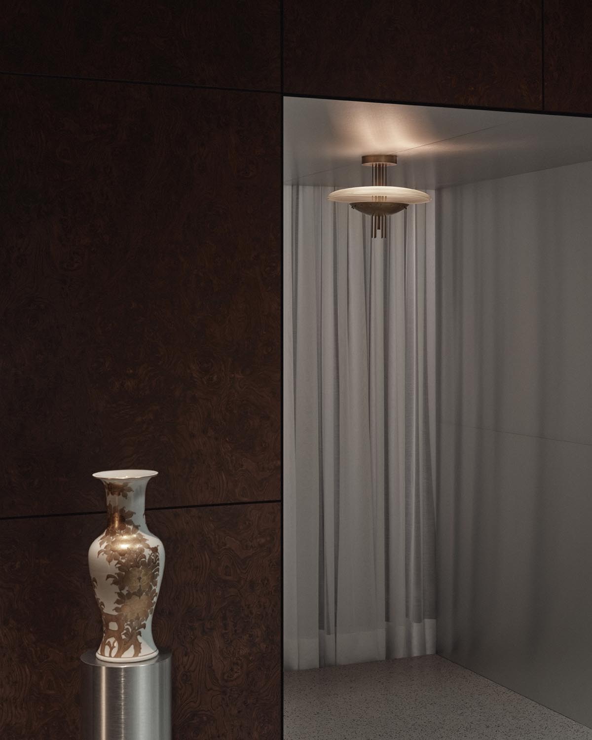 Ceiling light fixture with circular glass shade and bronze detailing above sheer curtains in minimalist interior corner
