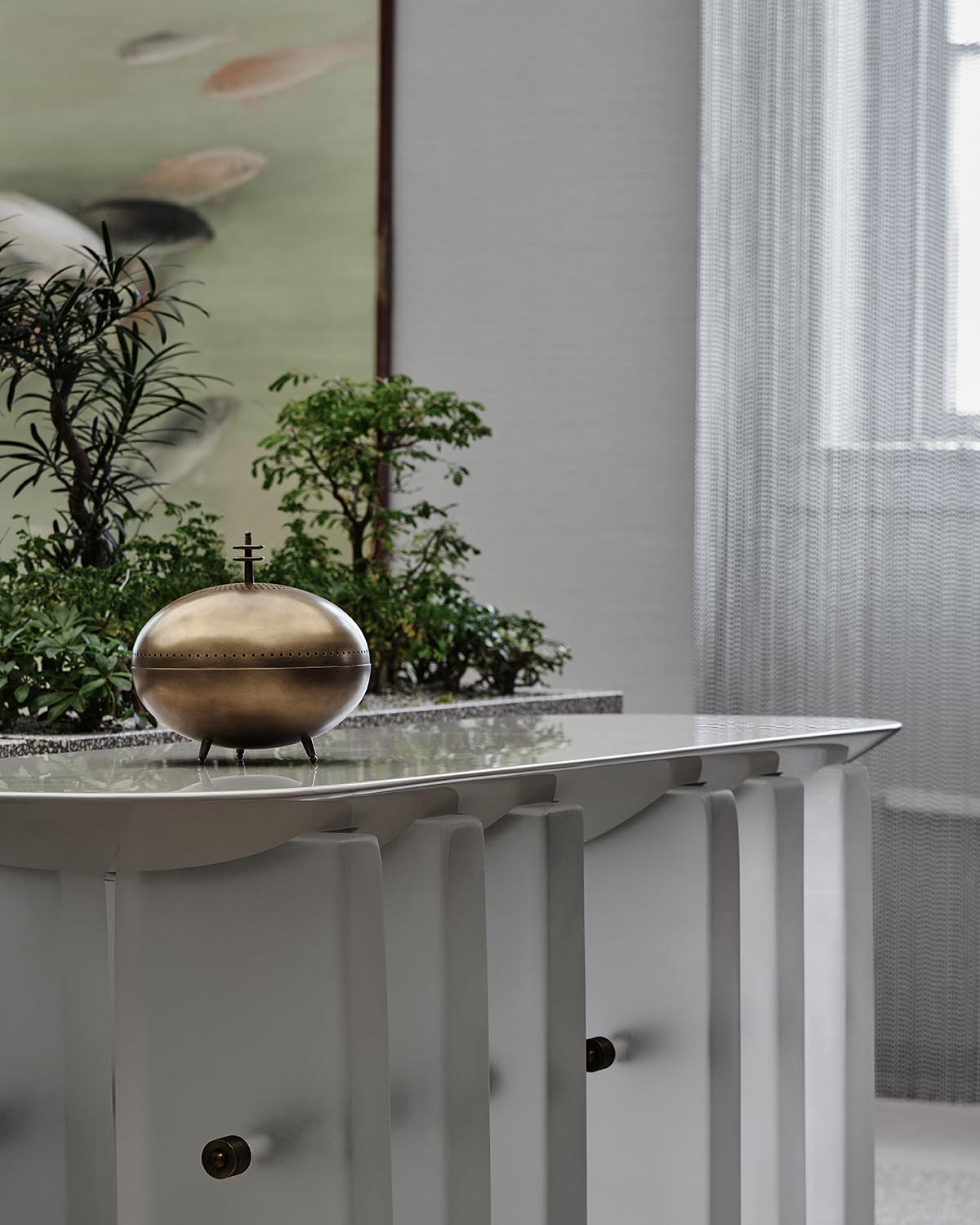A brass vessel on top of a gray lacquer console table, with plants in the background.