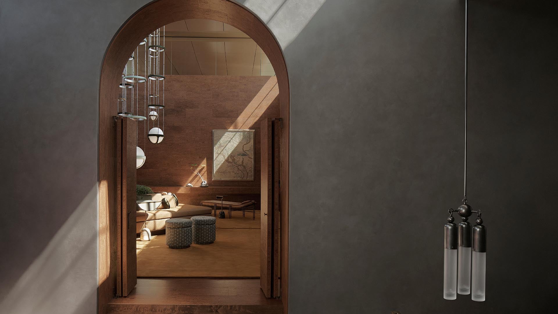 Interior view through a wooden arched doorway into a sunlit living space with textured stools and modern pendant lighting