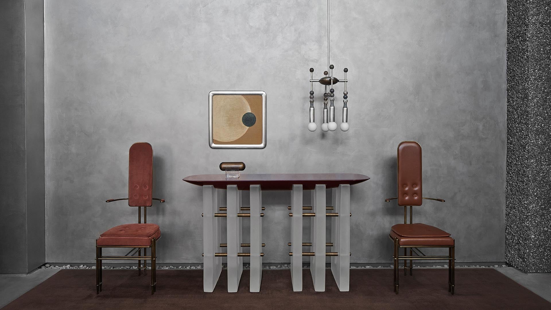 Minimalist interior with two brown leather chairs, a modern table with vertical slats, abstract wall art, and pendant lighting