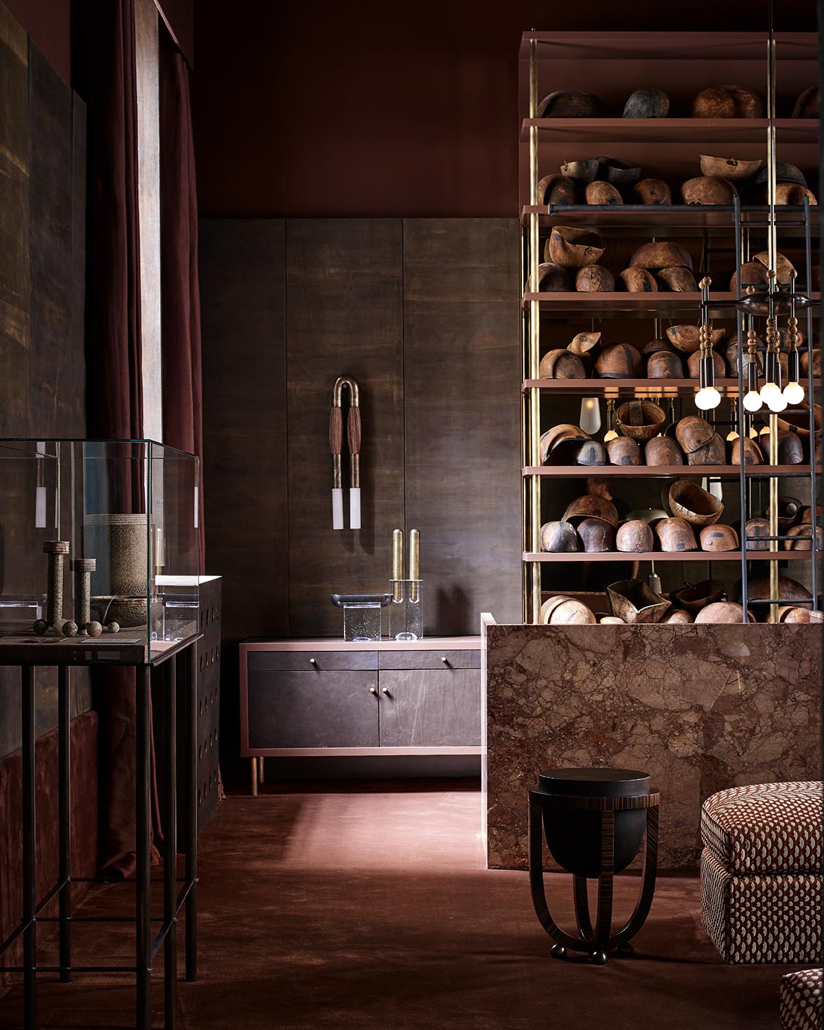 Interior with dark wood panel walls, shelves filled with rustic wooden objects, and warm ambient lighting fixtures