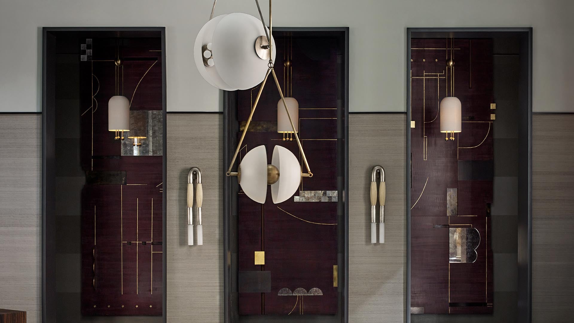 Contemporary wall installation with dark panels, geometric brass accents, and white spherical pendant lights in a neutral room